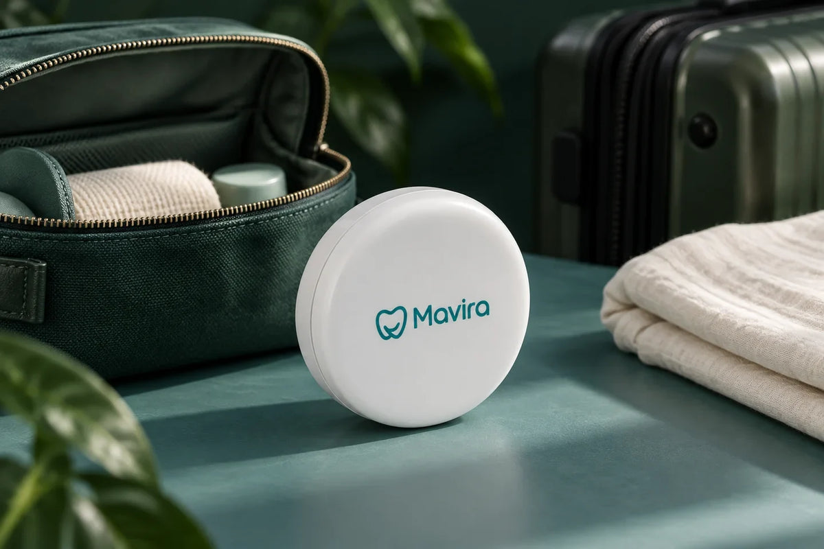 White Mavira retainer travel case beside a green toiletry bag and suitcase.