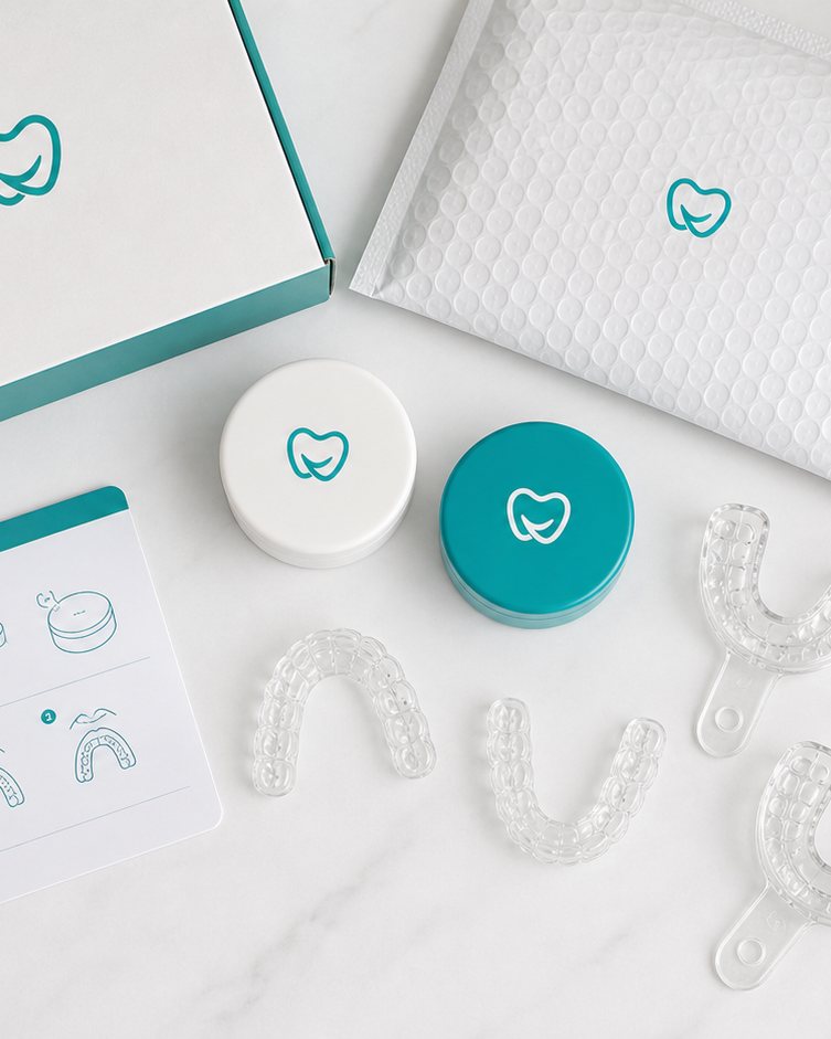 Mavira at-home retainer kit flat lay with impression trays, putty, mailer, case, and instructions